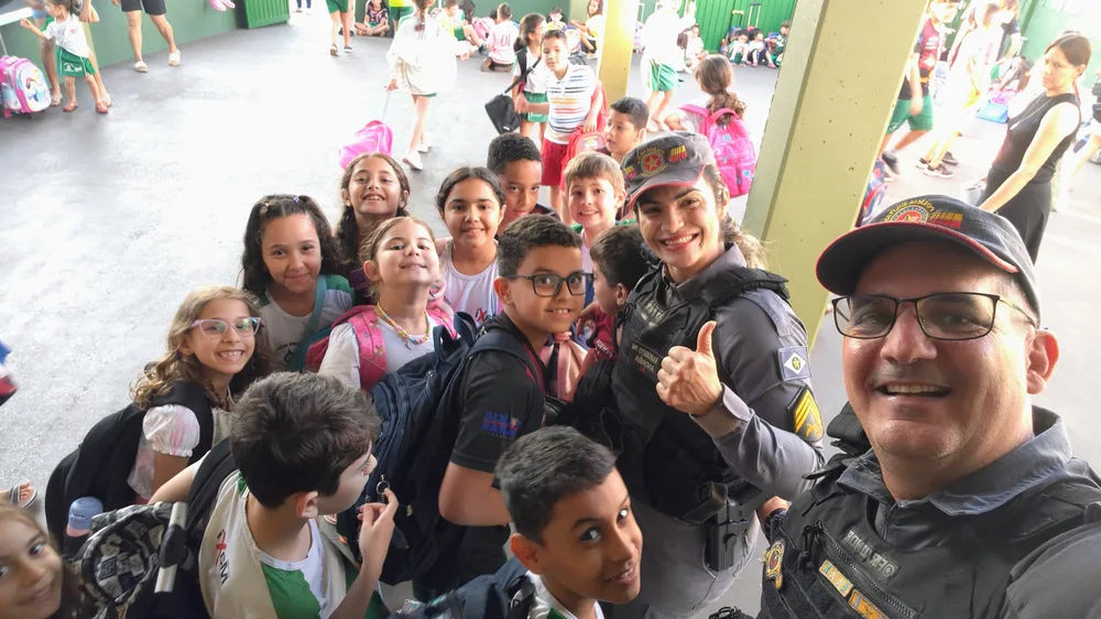 Andréia com estudantes na entrada da escola